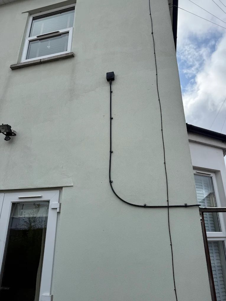 External CCTV cable and trunking neatly run on house exterior wall, Bristol
