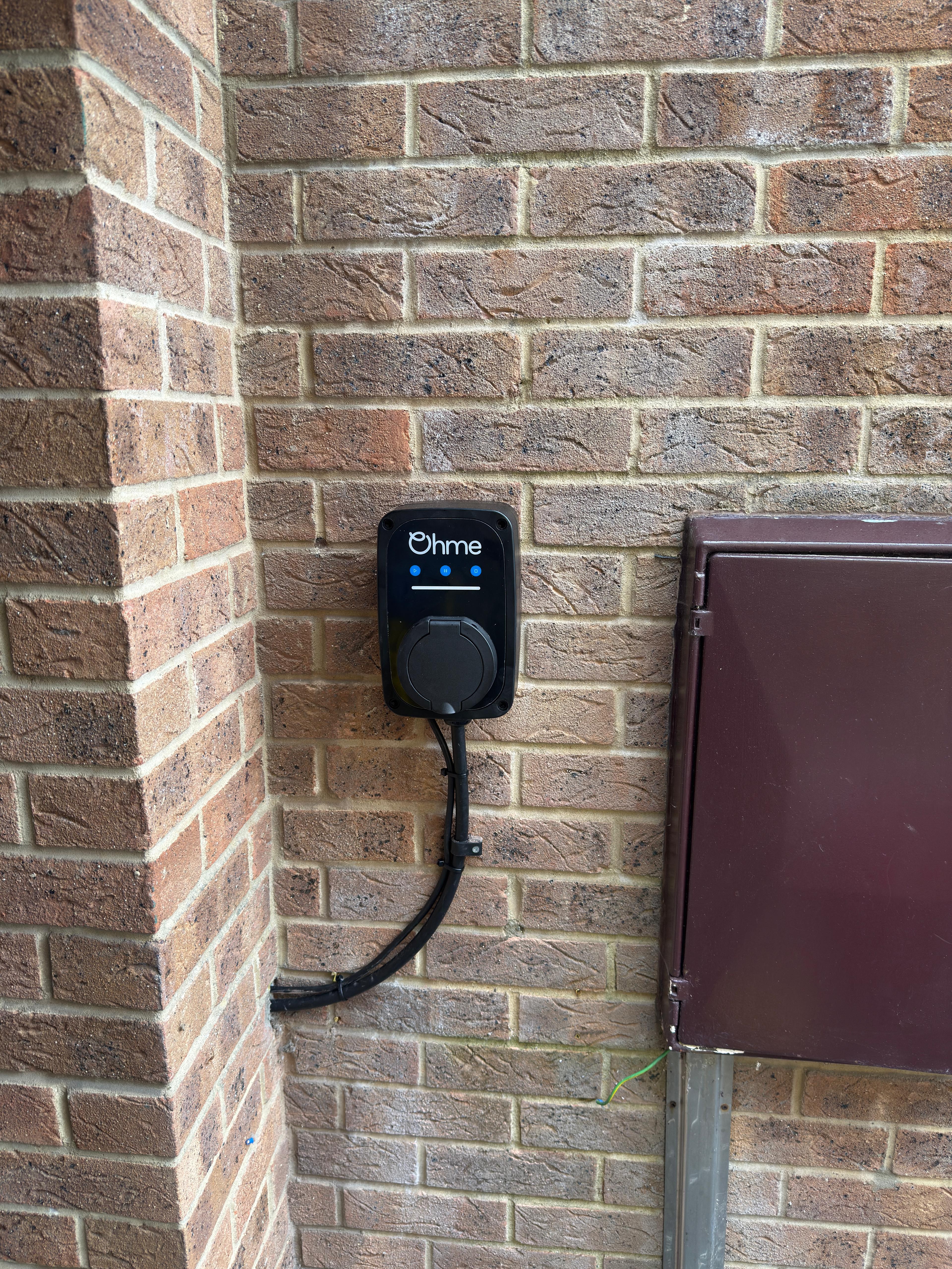 Ohme Home Pro EV charger mounted on a brick wall in Bristol